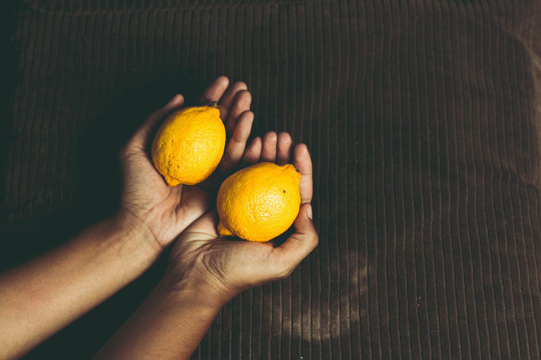 Two women smiling together with lemon slices, expressing joy and openness around body changes