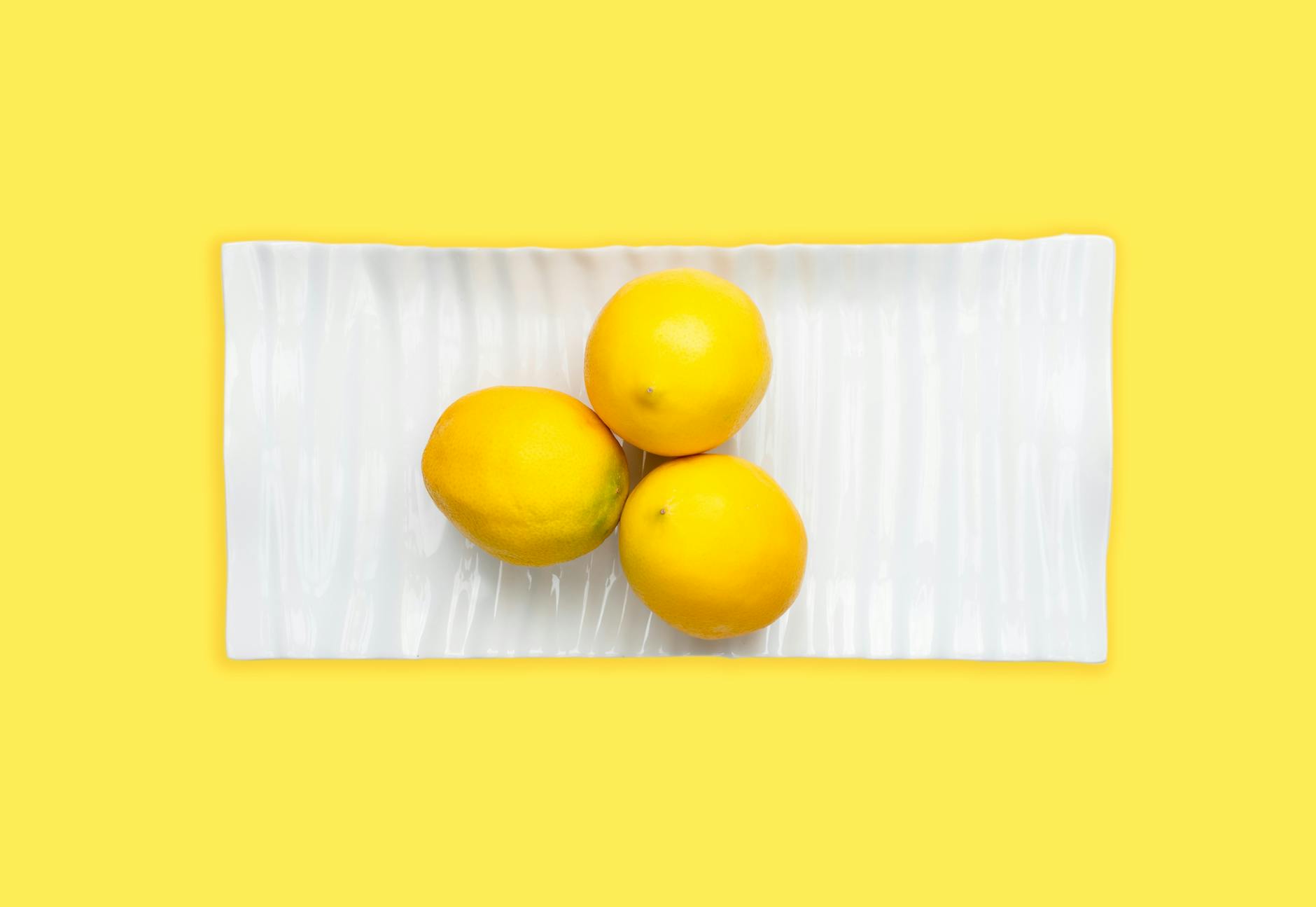 Woman holding multiple silicone lemon vibrators and considering which style fits her needs