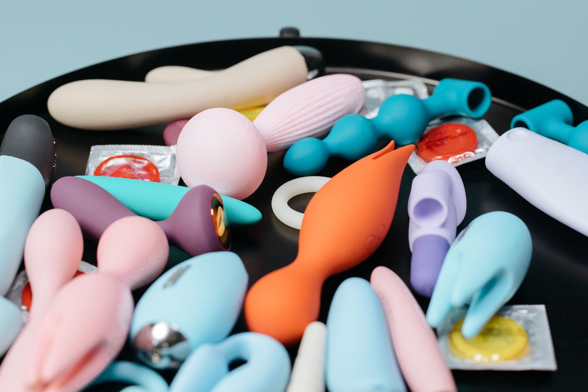 A colorful collection of vibrators and pleasure toys arranged on a tray