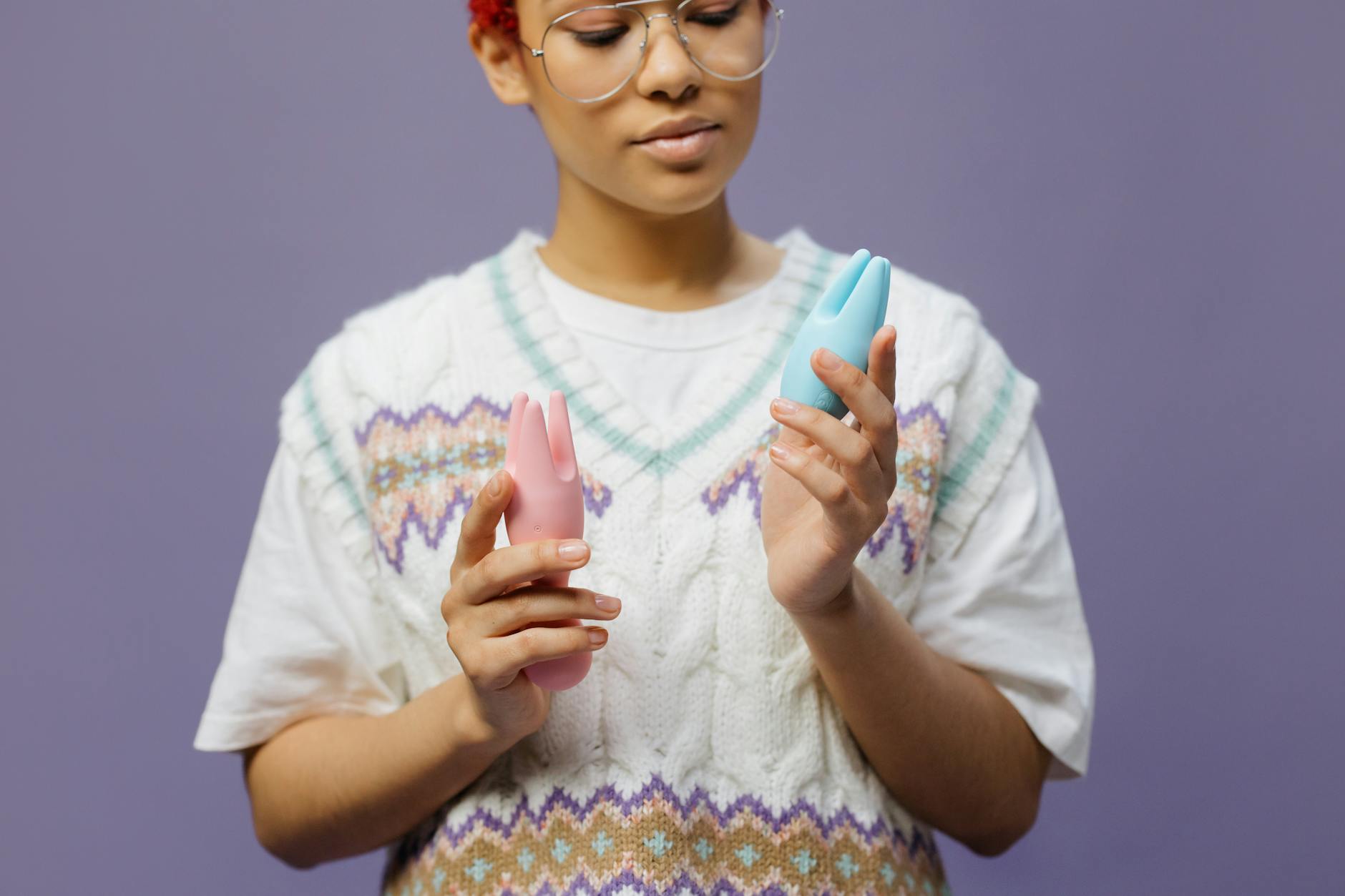 Woman holding a blue clitoral vibrator in contemplation, demonstrating intimate self-care