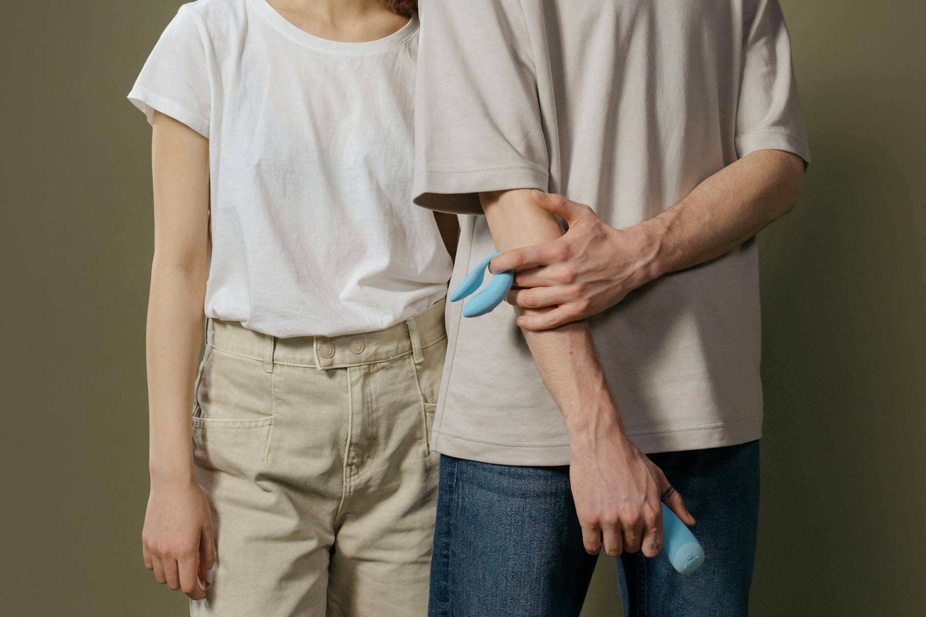 A hand holding a vibrant clitoral vibrator against a purple backdrop, representing modern pleasure and confidence after 50.